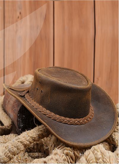 A brown, handcrafted, genuine leather cowboy hat with braided trim.